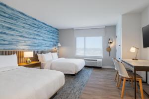 GenevaTownePlace Suites by Marriott Geneva at SPIRE Academy的酒店客房配有两张床和一张书桌