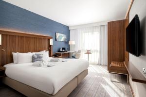 佩斯利格拉斯哥机场万怡酒店的一间酒店客房,配有一张大床和一台平面电视