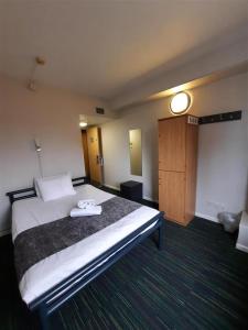 伦敦Kabannas London St Pancras的一间酒店客房,设有一张大床和一扇门