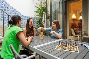 波尔图Porto Lounge Hostel & Guesthouse by Host Wise的三个女孩在桌上玩象棋