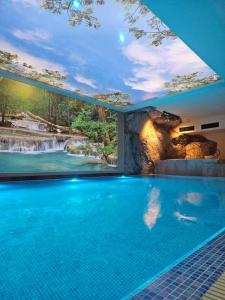 兹拉蒂博尔Zlatiborske terase Spa&Wellness的一座房子里一个带瀑布的游泳池