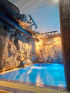 兹拉蒂博尔Zlatiborske terase Spa&Wellness的石墙洞里的一个大型游泳池