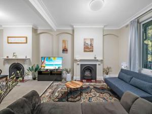悉尼4 bdrms house ICC & Darling Harbour & central & CBD & China Town的客厅配有蓝色的沙发和电视