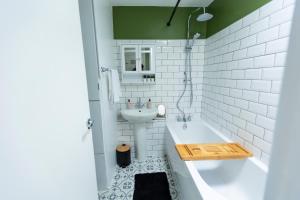 ThamesmeadGrace House - 15 Minutes To Central London的白色的浴室设有浴缸和水槽。