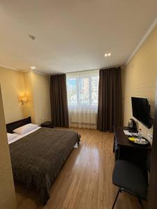捷尔诺波尔Passage Hotel的配有一张床和一张书桌的酒店客房