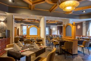 蒂奥内迪特伦托多洛米蒂索恩酒店的餐厅设有木制天花板和桌椅
