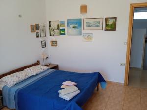 干尼亚Manolo s olive farm, apartment with seaview的一间卧室配有蓝色的床和毛巾
