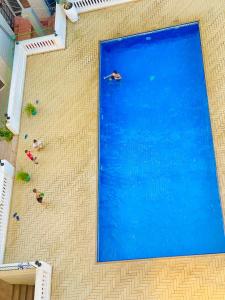 达累斯萨拉姆Platinum apartment的一座大型蓝色游泳池,那里有游泳的人