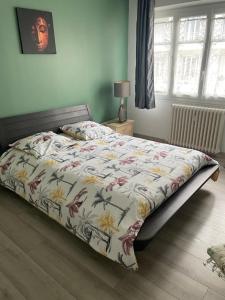 尼斯Nice appartement Avenue des Fleurs的一间卧室配有一张带花卉棉被的床