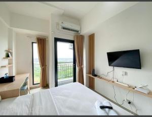 贝克西Capital O 93854 Apartemen Sayana By Sentra Jaya的一间卧室配有一张床和一台平面电视