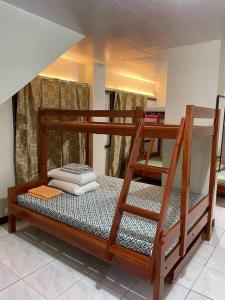 MatutinaoFamily Room near Kawasan Falls的配有梯子和两张床垫的双层床