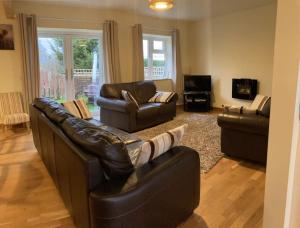 阿斯克Glenview Lodge accommodation, Monmouthshire的客厅配有两张真皮沙发和一台电视机