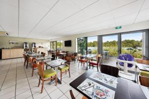 拉特斯特德布赫拉特斯特全套房酒店 - 阿卡雄湾的用餐室设有桌椅和窗户。