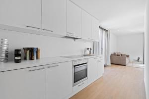 洛桑Boissonnet 96 Residence by Homenhancement的白色的厨房设有水槽和炉灶。