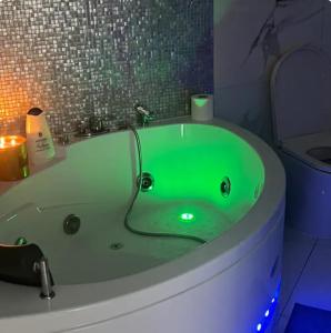 克雷莫纳Luxury home stanza in appartamento condiviso的配有蜡烛的浴室内的绿色浴缸