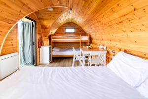洛西茅斯Camping Pods Silver Sands Holiday Park的小木屋内的卧室,配有一张床和一张桌子