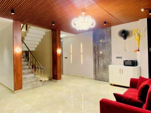 巴雷利Hotel Krishna Residency Bareilly Near Ashish Royal Park的一间带红色沙发的客厅和楼梯
