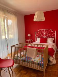 波尔图100康托斯住宿加早餐旅馆的红色的卧室设有婴儿床和红色的墙壁