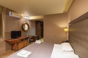 尼奥楚里翁尼夫罗斯度假酒店及Spa中心的酒店客房,配有床和电视