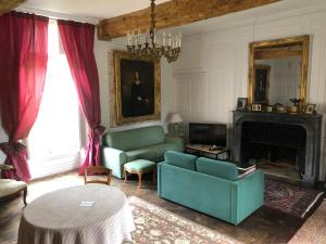 HillionChambres d'hôtes Château de Bonabry的客厅设有绿色沙发和壁炉