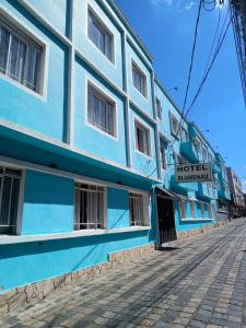 库里提巴Hotel Blumenau Centro的街道边的蓝色和白色建筑