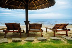 美奈美奈孟青假日酒店的海滩上两把椅子放在伞下