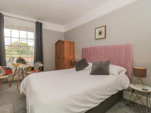 汤顿Buckland House Annex的一间卧室配有一张带粉红色床头板的大床