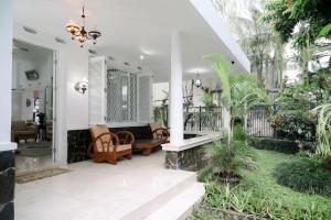 茂物Kirana Guest House Bogor的门廊配有沙发、椅子和植物