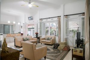茂物Kirana Guest House Bogor的客厅配有沙发、椅子和电视