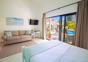 苏莎亚海滨花园旅馆的一间卧室设有一张床和一间客厅。