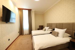 巴尼亚卢卡维多维奇酒店的酒店客房设有两张床和一台平面电视。