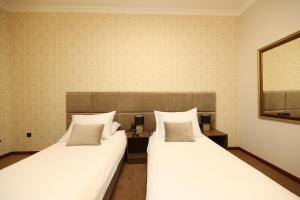 巴尼亚卢卡维多维奇酒店的两张睡床彼此相邻,位于一个房间里