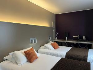 香槟沙隆HOTEL & SPA Le Renard Centre的酒店客房 - 带两张带橙色枕头的床