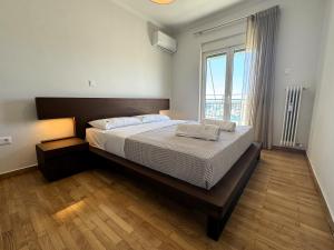 比雷埃夫斯Piraeus center sea view apartment的一间卧室设有一张大床和一个大窗户