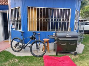 底拉斯卡拉Rústica Azul的一辆自行车停在蓝色房子旁边,上面有烤架