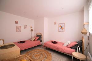 亚眠Dewailly, 3 couchages, élégant, proche centre ville的配有红色床单和桌子的客房内的两张床