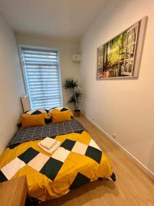 卢布林Apartment Targowa L7的一间卧室配有一张带黄色和黑色枕头的床