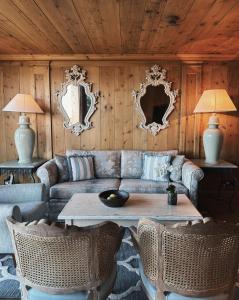 克莱恩 蒙塔纳LeCrans的客厅配有沙发、桌子和镜子