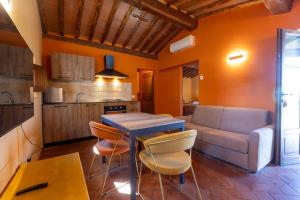 阿夏诺Podere Sant'Antonio的厨房以及带桌子和沙发的客厅。