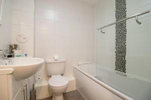 佩斯利2 bed flat near airport &parking的浴室配有卫生间、盥洗盆和浴缸。