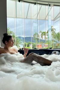 乌巴图巴温布利酒店 的躺在浴缸中的女性,可以欣赏美景