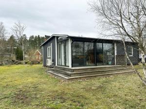 HagbyNice cottage located in Sandvik, 100 meters from a bay的院子内玻璃门的小房子