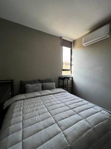 比亚埃尔莫萨Torre Polvora Departamento by AIRA Mexico的一间卧室设有一张大床和一个窗户。