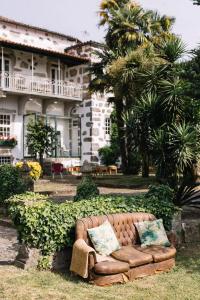 布拉加Casa da Pedra Cavalgada的坐在房子前面的草上的一个沙发