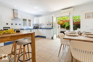 卡尔佩Villa Oasis by Abahana Villas的厨房配有白色橱柜和桌椅