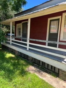 纳奇兹Wensel Cottage in downtown Natchez的草上长门廊的房子