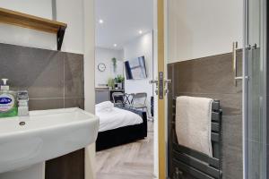 伯恩茅斯Wimbourne Road Apartment 1的一间带水槽的浴室和一间带一张床的卧室