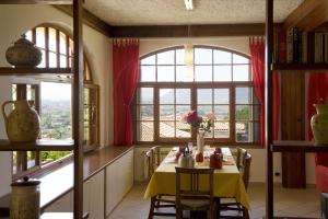 卡斯泰尔诺沃马格拉Casa Vacanze Colline di Luni的一间带桌子和大窗户的用餐室