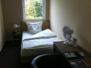 杜塞尔多夫21目的地酒店的一间卧室配有一张带窗户的床和风扇