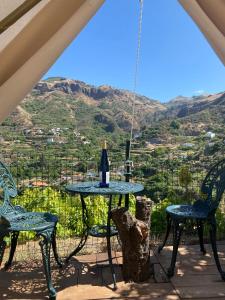 贝加德圣马特奥Angel Caves Farmstay的桌椅和一瓶葡萄酒